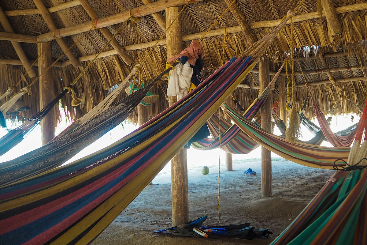 Viele Hängematten in einer Hütte.