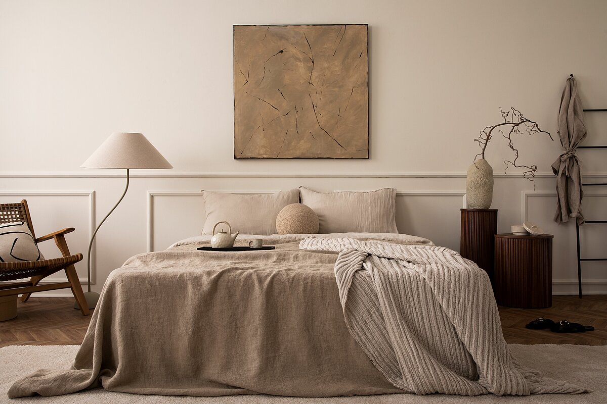 Cremefarbendes Schlafzimmer mit einem Bett im Vordergrund.